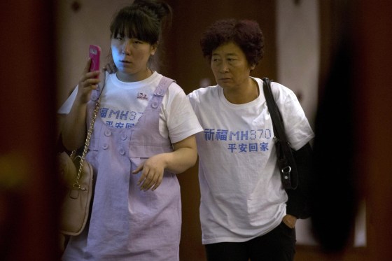 Image: Relatives of Chinese passengers aboard the missing Malaysia Airlines, MH370, walk out from a meeting room in a hotel wearing a t-shirt which reads "Pray for MH370 safe return" in Beijing, China