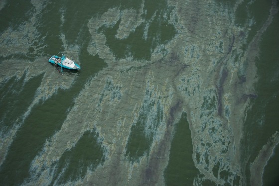 A vessel surrounded by a sheen on the water near the Port of Galveston on Sunday, March 23, 2014, in Galveston, Texas. Dozens of ships are in evolved in clean-up efforts to remove oil that spilled into Galveston Bay after a ship and barge collided near the Texas City dike on Saturday afternoon. (AP Photo/ Houston Chronicle, Smiley N. Pool)