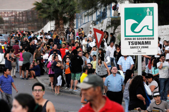 Image: People stay on higher grounds in a tsunami safety zone after a magnitude 6.7 earthquake shook the region, in Iquique city, north of Santiago