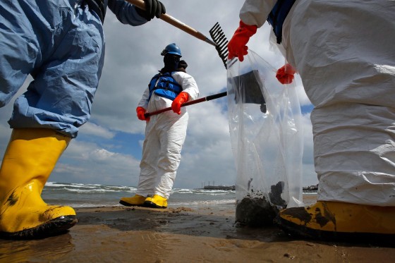 Image: Oil spill response contractors clean up crude oil on a beach after a BP oil spill on Lake Michigan in Whiting