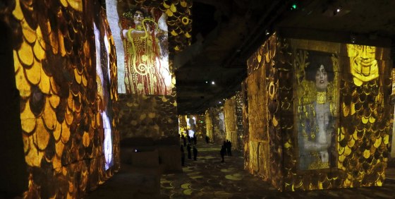 Visitors look at a sound and light show as part of the exhibition 'Klimt and Vienna, a Century of Gold and Colours', projected on the walls of the 'Carrieres de Lumieres' site (Quarries of Lights) in Les Baux-de-Provence, France on March 25.