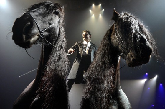 Image: Circus artist Maycol Errani stands on two horses