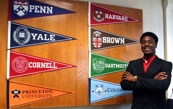 Kwasi Enin poses with banners from the Ivy League colleges where he was accepted.