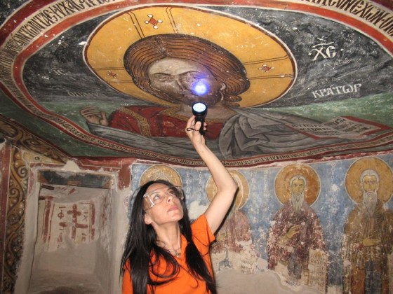 Image: UCLA archaeologist Ioanna Kakoulli examines a painting in the monastery under UV light