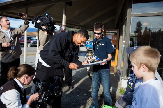 Image: Seattle Seahawks linebacker Malcolm Smith, center, signs autographs outside the Darrington Community Center
