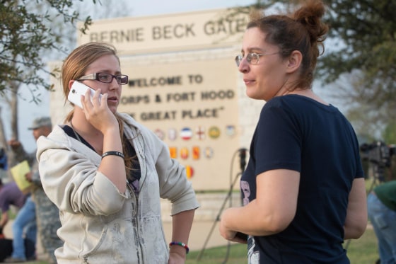 Krystina Cassidy and Dianna Simpson attempt to make contact with their husbands who are stationed inside Fort Hood, while standing outside of the Bernie Beck Gate, on April 2, 2014, in Fort Hood, Texas. 