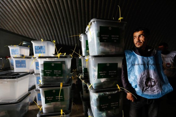 Image: Afghan election worker stands next to ballot boxes at a counting centre in Kabul