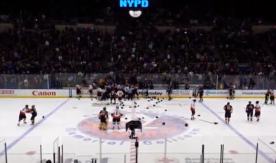 In this image taken from video provided by Ken Turnlund, players brawl during the second period of an annual charity hockey match between New York City police and firefighters Sunday, April 6, at Nassau Coliseum in Uniondale, N.Y. The NYPD eventually won 8-5.