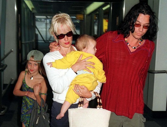 Michael Hutchence and Paula Yates, carrying Heavenly Hiraani Tiger Lily, with Peaches walking alongside at London’s Heathrow Airport in 1997.
