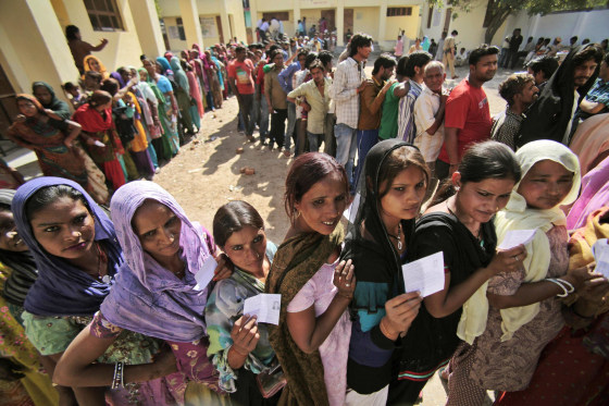 Indians stand in a queue to cast their votes outside a polling station during parliamentary elections in Jammu