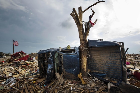 Image: The body of a pickup truck is wrapped around a tree trunk after being thrown there by by a tornado in Moore, Oklahoma in this file photo
