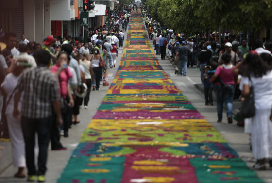 Image: People walk next to a traditional Guatemalan traditional sawdust carpet during Holy Week celebrations, in downtown Guatemala City