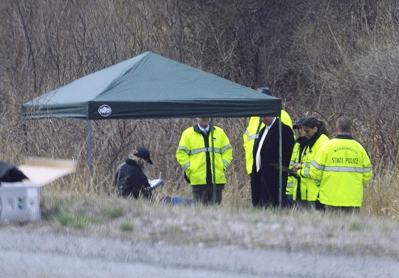 Image: Massachusetts State Police stand along Interstate 190 where police said a child's body was found near Sterling, Mass.