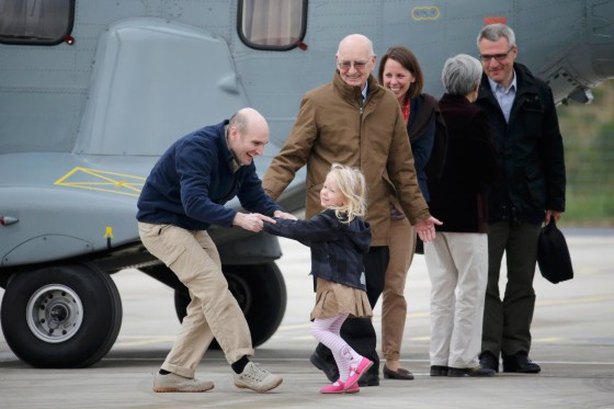 Image: Former French hostage and journalist Nicolas Henin is greeted by his family moments after a transfer by helicopter from Evreux to the military airbase in Villacoublay