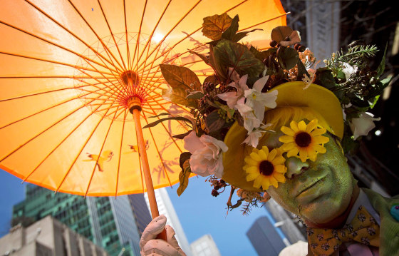 Image: A participant dressed in costume holds an umbrella at the annual Easter Bonnet Parade in New York