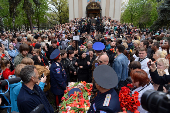 Image: Ukraininan people attend the funeral ceremony of men killed in a gunfight on April 20 in the eastern Ukrainian city of Slovyansk