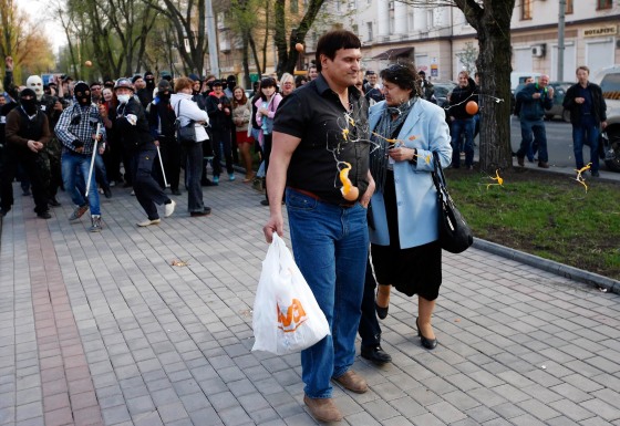 Image: Masked pro-Russia protesters pelt supporters of Yulia Tymoshenko with eggs outside a regional government building in Donetsk