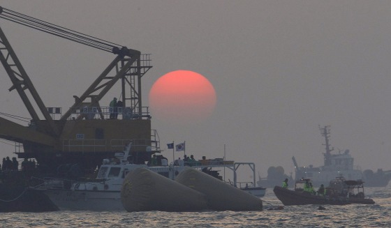 Image: The sun sets as searchers and divers look for bodies of missing passengers onboard the sunken South Korean ferry