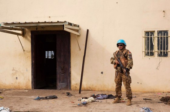 Image: A United Nations peacekeeper stands guard near the scene where about 200 people were killed during an attack in Bentiu