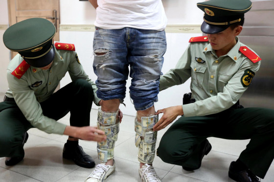 Man straps dollar banknotes to legs seized in Shenzhen