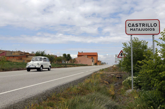 Image: A car passes by the road sign at the entrance of the small Spanish town of Castrillo Matajudios