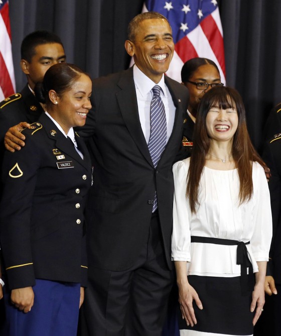 Image: U.S. President Barack Obama poses with new American citizens at a naturalization ceremony at the National War Memorial in Seoul