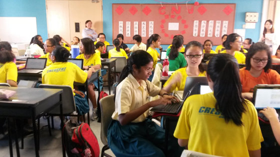 Students at Crescent Girls School in Singapore discuss conflict and discrimination in groups while working on a shared Google Doc.