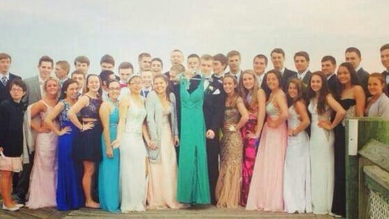 Friends of Maren Sanchez hold up the dress she would have worn at prom.