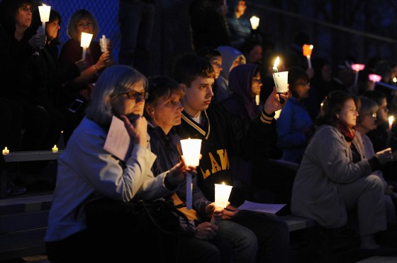 Image: People raise candles at a vigil for Maren Sanchez