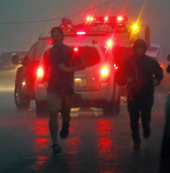 Image: A volunteer joins a first responder after a tornado hit Louisville, Miss.
