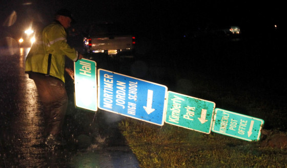 An officer moves a sign from the road after a possible tornado passed through, damaging homes and business on Monday, April 28, in Kimberly, Ala.