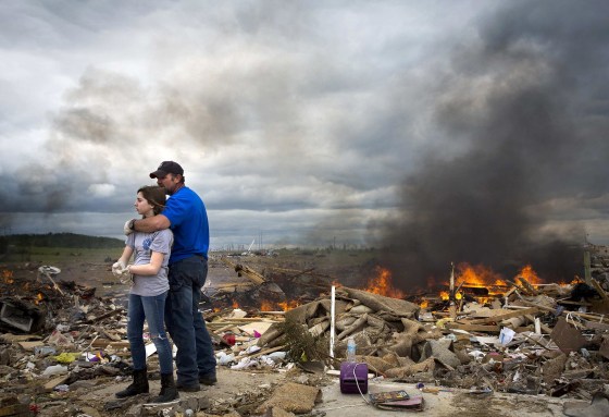 Michael Stanek hugs his daughter Kennedy as they take a break from helping friends sift though the rubble of their homes in Vilonia, Ark. on April 30. Severe floods in Florida's Panhandle and coastal Alabama deluged roads and engulfed homes and cars on Wednesday, the latest mayhem created by a tornado-packing storm system that has killed at least 34 people in the United States this week.