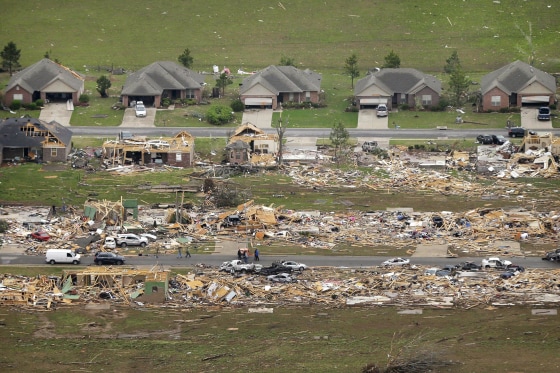 Image: A row of lightly damages houses, top, face destroyed homes in a Vilonia, Ark., neighborhood Monday
