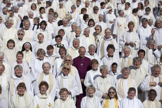 Image: The Archbishop of Canterbury Justin Welby poses with female priests after their march celebrating the twentieth anniversary of women becoming ordained priests in the Church of England in London