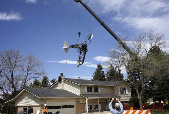Image: Wreckage of a small plane that crashed into a house is lifted by a crane in Northglenn