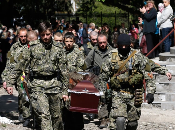 Image: Pro-Russian gunmen carry the coffin of a person killed in Slovyansk