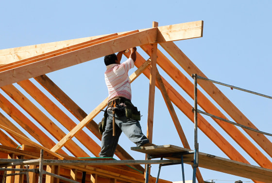 Image: A construction worker works on the framework for a single family home under construction in Los Angeles