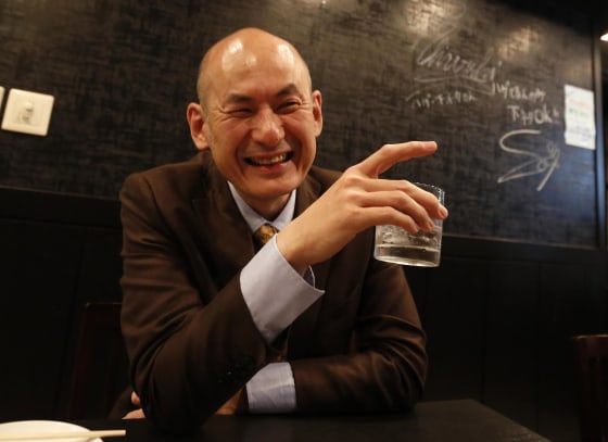 Shiro Fukai, 48, smiles as he drinks distilled spirit at the Otasuke "izakaya" style pub and restaurant in Tokyo May 8, 2014.