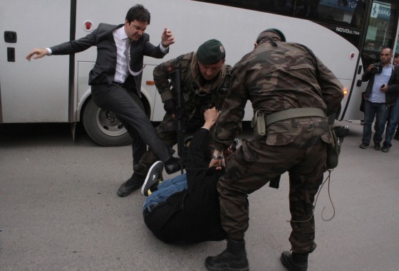 Image: A protester is kicked by Yusuf Yerkel, advisor to Turkey's Prime Minister Tayyip Erdogan, as Special Forces police officers detain him during a protest against Erdogan's visit to Soma