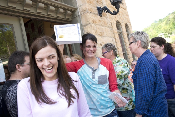 Image: Kristin Seaton holds up her marriage license as she leaves the courthouse in Eureka Springs, Ark., with her partner, Jennifer Rambo.