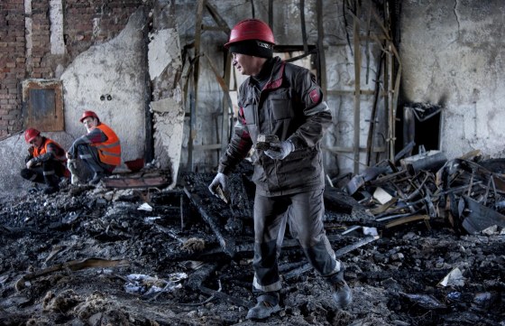 Image: Workers of the Ukrainian company Metinvest clear away debris in a government building in the eastern Ukrainian city of Mariupol