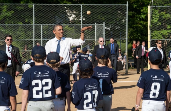 President Barack Obama tosses a ball to Little League baseball players as they warm up prior to games at Friendship Park in Washington on May 19, 2014.