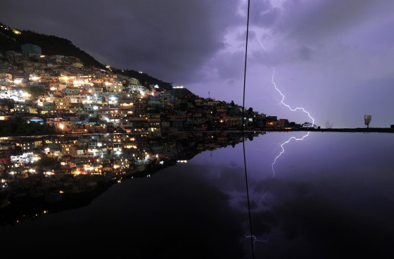 Image: A long exposure shows lightning in the sky with reflection in the water