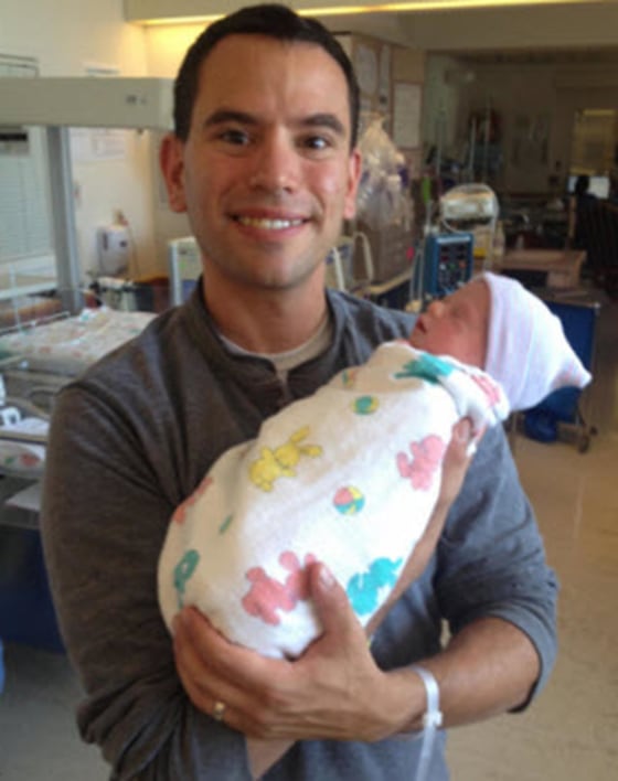 Image: Brian Lande holds his baby, who was born while his wife was in a coma.