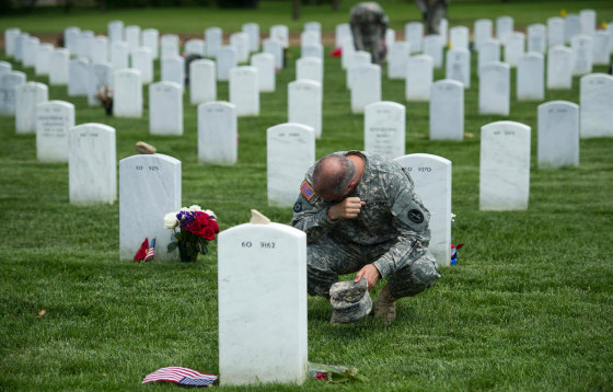 Image: Army Col. Matthew Rasmussen wipes tears from his eyes while visiting the grave of Army Staff Sgt. Richard Tieman, 28, of Waynesboro, Pa.