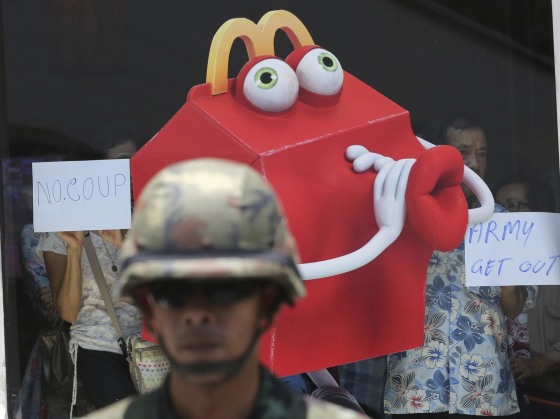 A Thai soldier guards outside a shopping mall during an anti-coup demonstration in Bangkok, Thailand, Sunday, May 25, 2014. Gen. Prayuth Chan-ocha in Thailand's ruling junta warned people Sunday not to join anti-coup street protests, saying normal democratic principles cannot be applied at the time, as troops fanned out in central Bangkok to prevent rallies. (AP Photo/Sakchai Lalit)