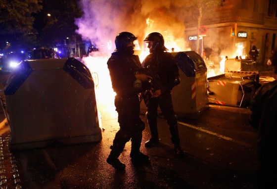 Image: Police stand next to burning containers during a protest against the eviction of squatters from Can Vies building at Sants neighbourhood