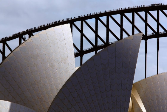 Climbers walk along the arch of Sydney Harbor Bridge behind the Sydney Opera House on May 30, 2014 as they attempt to break the record for the most number of people on the arch of the famous bridge at the same time.