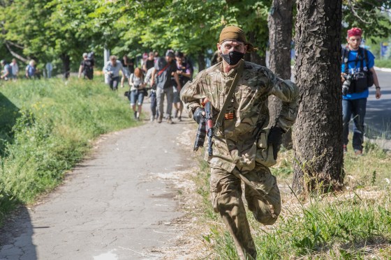 Image: A separatist combatant gets himself to safety during the fighting at Donetsk airport in Donetsk