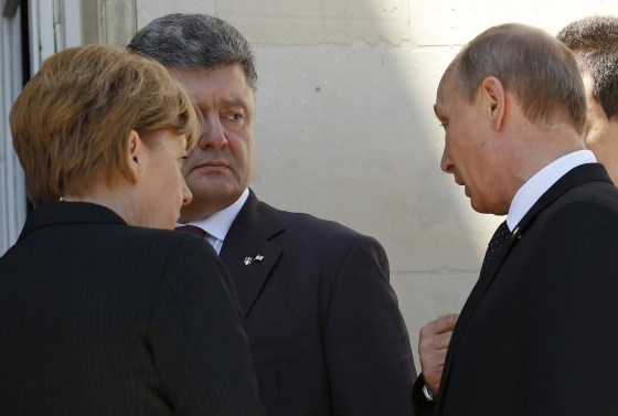 Ukraine president-elect Petro Poroshenko, second from left, German Chancellor Angela Merkel and Russian President Vladimir Putin talk after a group photo during the 70th anniversary of the D-Day landings in Benouville, France, on June 6, 2014.